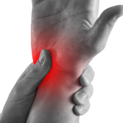 black and white image of person rubbing their wrist, which is colored red to show pain